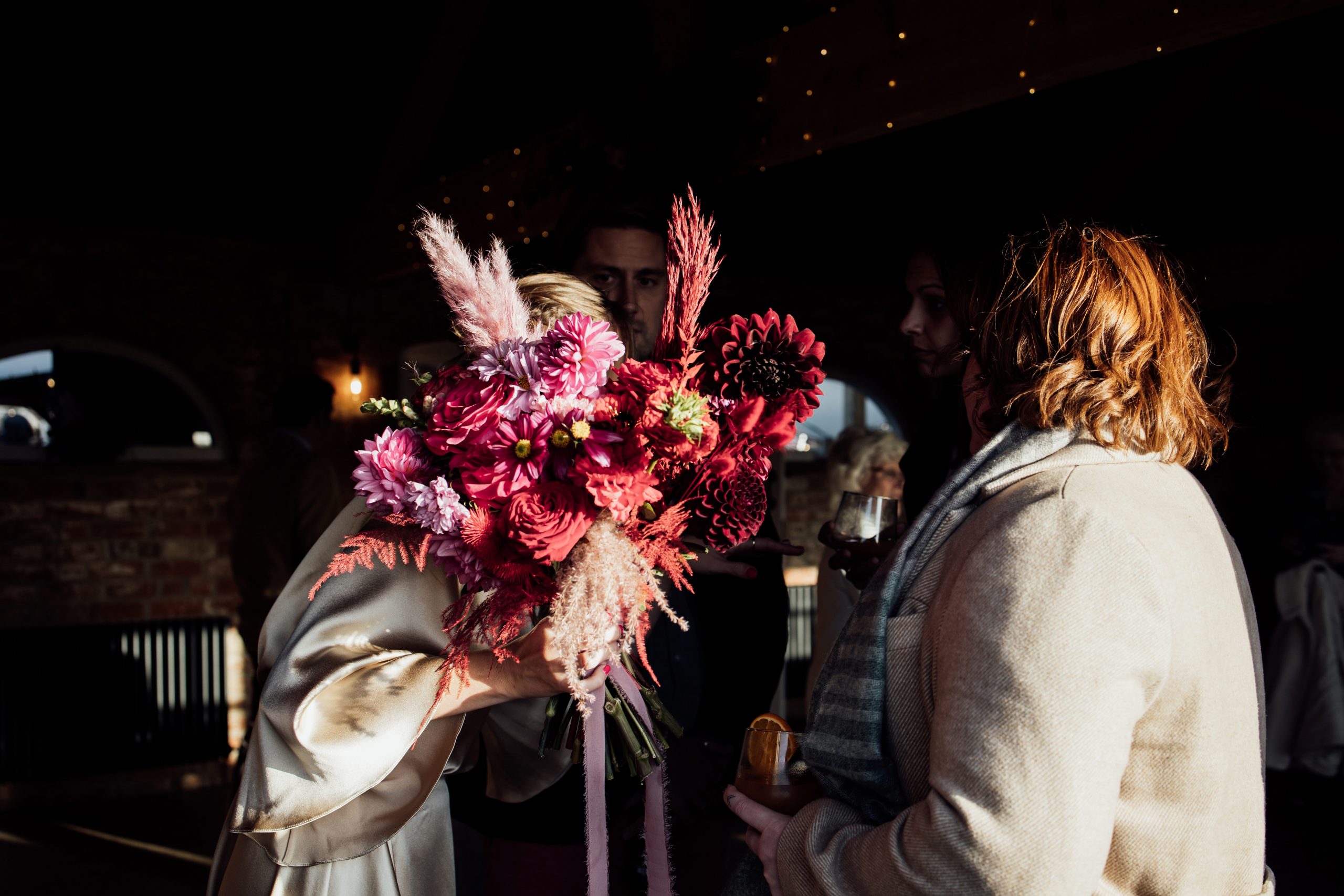 A wedding bouquet filled with coloured pampas grass and pink and red flowers