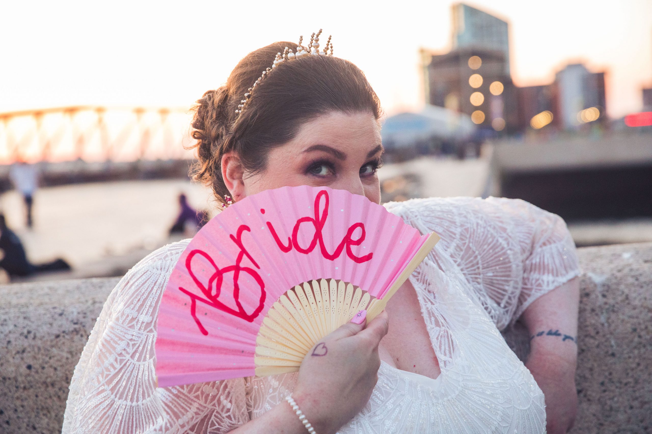 woman holding pink fan with the words bride written on it