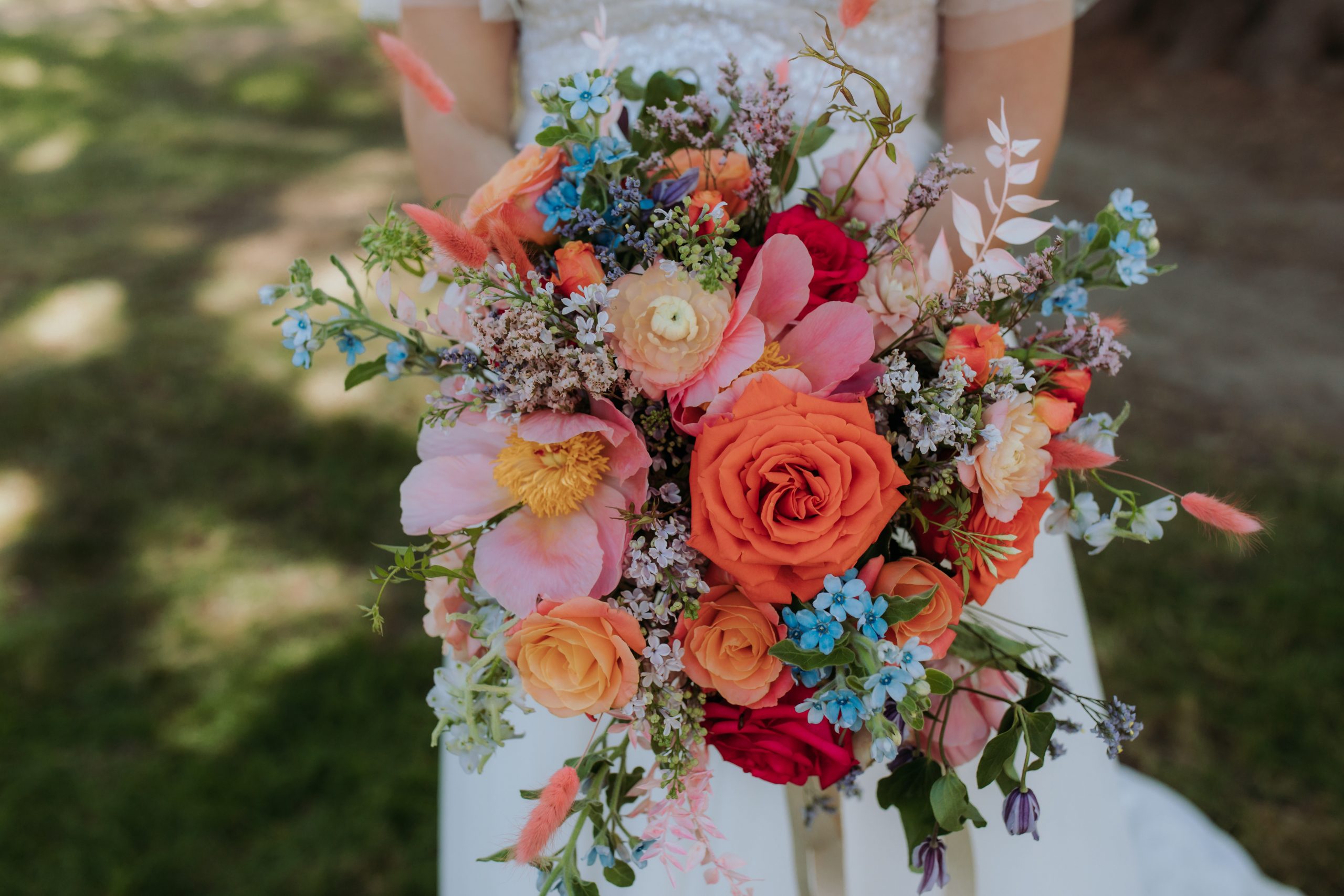 A bright and colourful bouquet filled with pink, orange and blue flowers