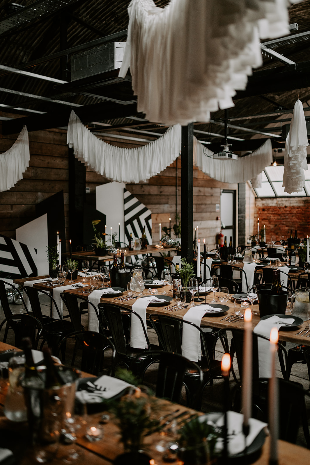 A industrial wedding venue filled with white streamers and black and white decor