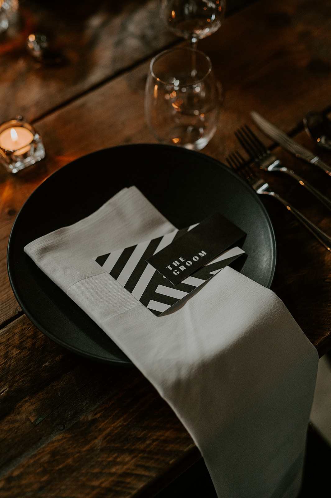 black plate with white napkins and black and white place cards