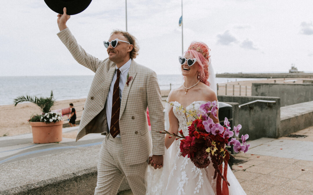 couple walking along Ramsgate beach in cool wedding attire