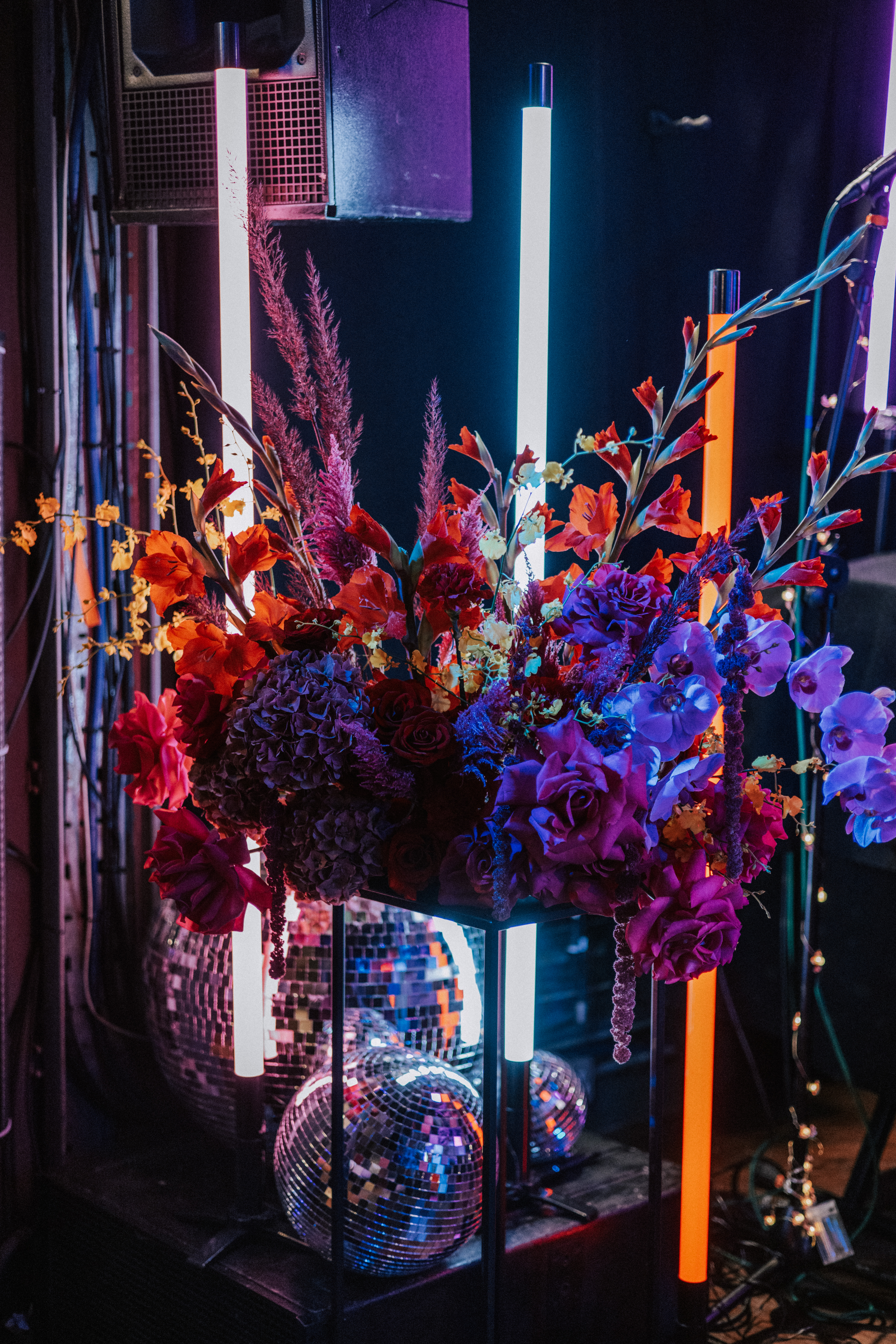 Large colourful floral display styled with neon poles and disco balls